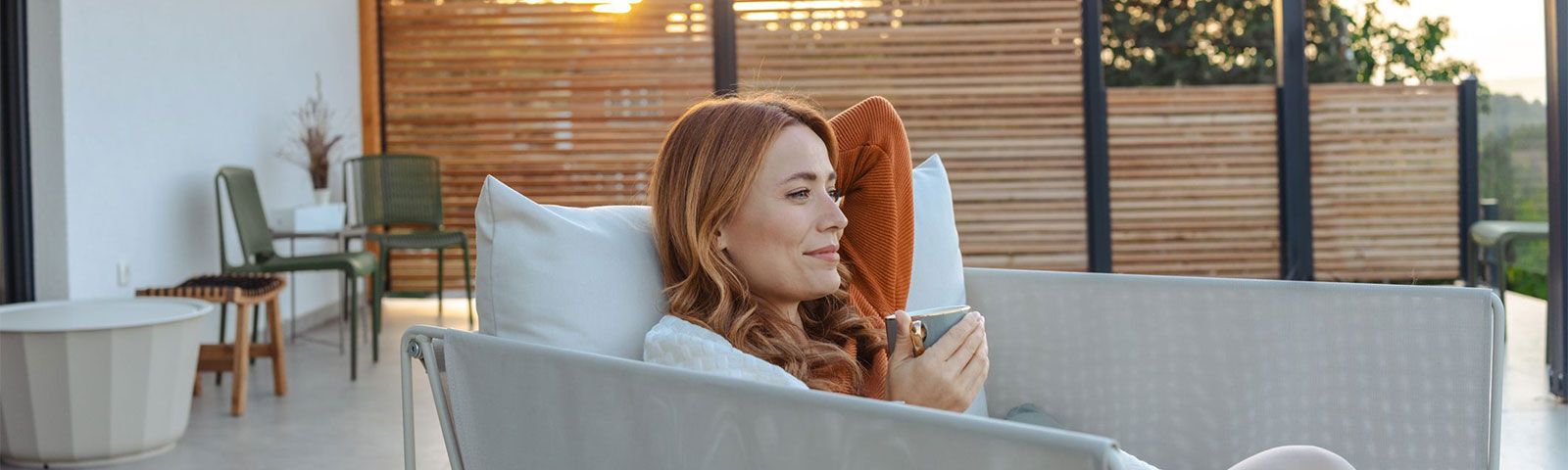 a woman drinking coffee on her patio